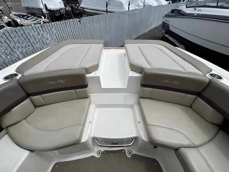 Slide: The Image of 2012 Sea Ray 250 SLX boat interior with beige seating and cup holders. - 19