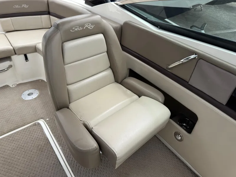 Slide: The Image of 2012 Sea Ray 250 SLX boat interior with beige seating and carpeted flooring. - 22