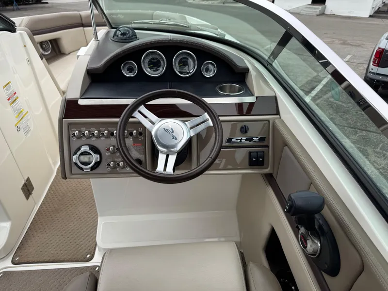 Slide: The Image of 2012 Sea Ray 250 SLX boat dashboard with steering wheel and control panel. - 24
