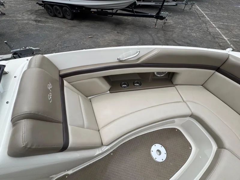 Slide: The Image of Luxurious seating area on a 2012 Sea Ray 250 SLX boat, featuring beige upholstery. - 28