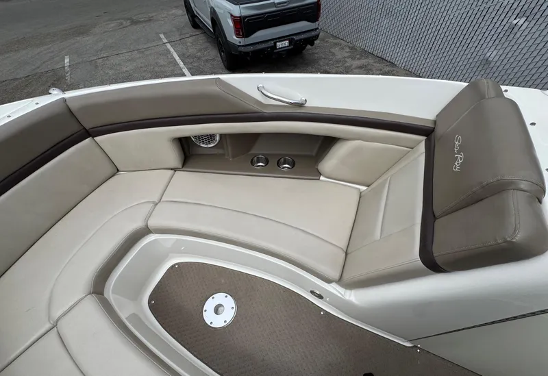 Slide: The Image of Luxurious seating on 2012 Sea Ray 250 SLX boat, featuring beige upholstery and cup holders. - 29