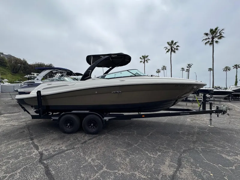 Slide: The Image of 2012 Sea Ray 250 SLX boat on trailer, parked outdoors with palm trees in background. - 3