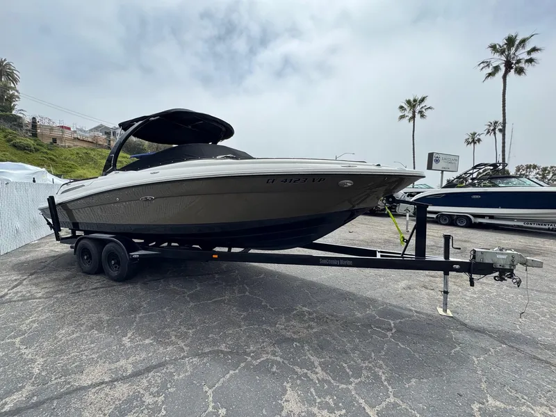 Slide: The Image of 2012 Sea Ray 250 SLX boat on trailer, parked outdoors with palm trees in background. - 6
