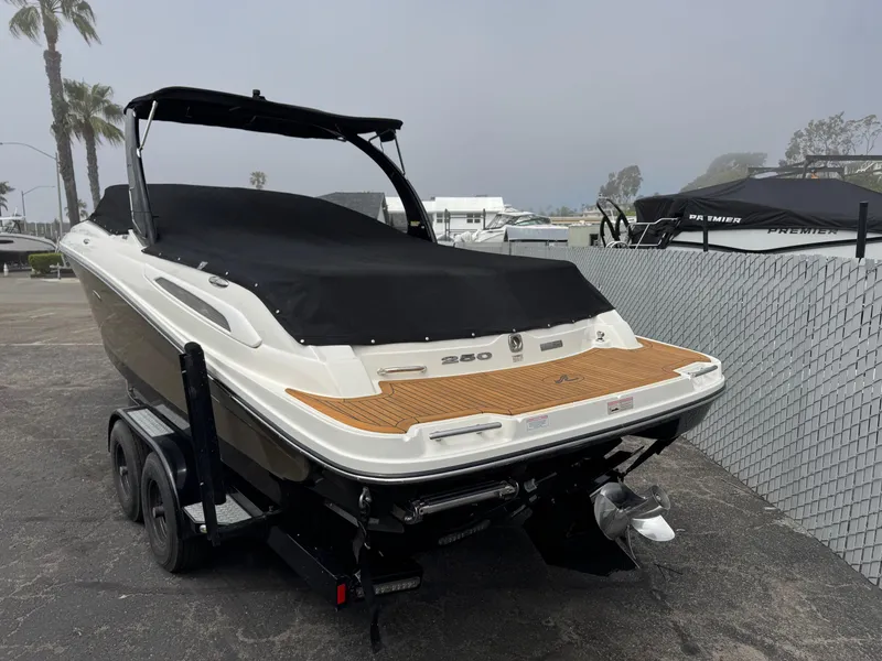 Slide: The Image of 2012 Sea Ray 250 SLX boat on trailer, covered, parked near marina. - 9