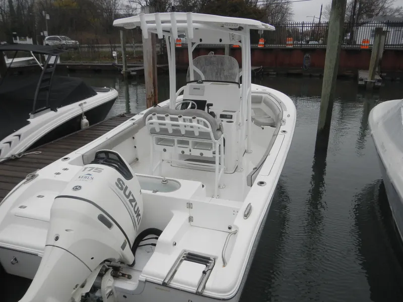 Slide: The Image of 2018 Sea Pro 219 Center Console boat docked, featuring a Suzuki outboard motor. - 1