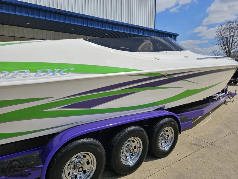 Slide: The Image of 2007 Nordic 28 Heat MCOB boat with green and purple accents on a trailer. - 11