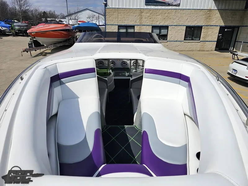 Slide: The Image of 2007 Nordic 28 Heat MCOB boat interior with white and purple seating, docked outdoors. - 20