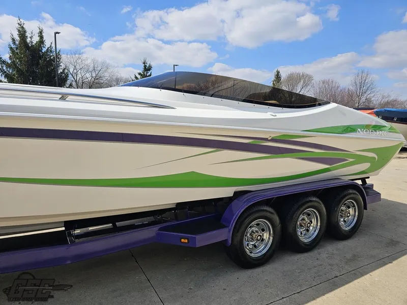 Slide: The Image of 2007 Nordic 28 Heat MCOB boat with vibrant green and purple accents on a trailer. - 25