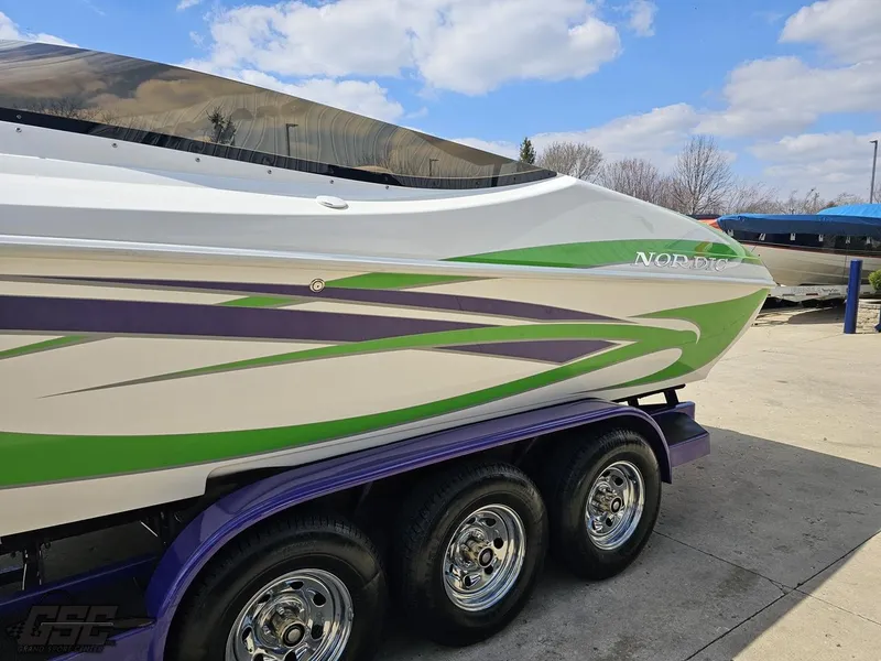 Slide: The Image of Nordic 28 Heat MCOB boat, 2007 model, with vibrant green and purple accents on a trailer. - 26