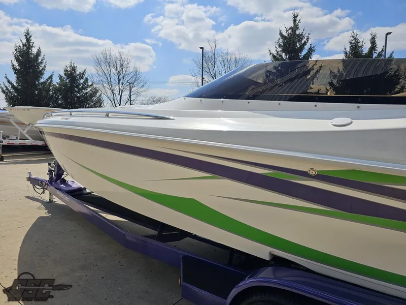 Slide: The Image of 2007 Nordic 28 Heat MCOB boat with green and purple accents on a trailer. - 28
