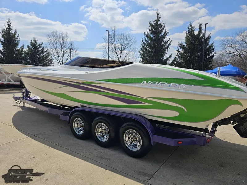 Slide: The Image of 2007 Nordic 28 Heat MCOB boat with green and purple accents on a trailer. - 30