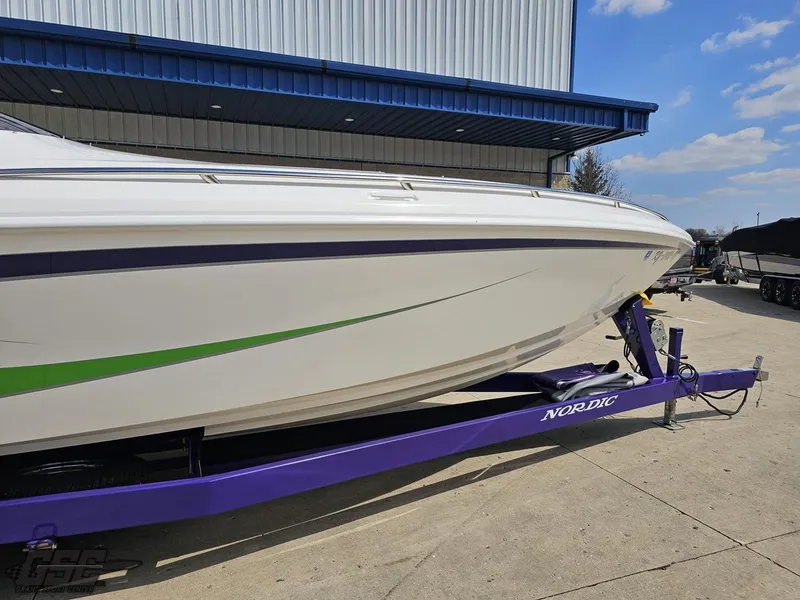 Slide: The Image of 2007 Nordic 28 Heat MCOB boat on a purple trailer, parked outside a building. - 6