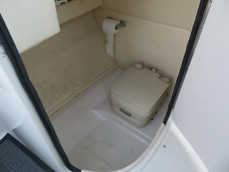 Slide: The Image of 2004 Sea Ray 220 Sundeck interior with portable toilet and toilet paper holder. - 4