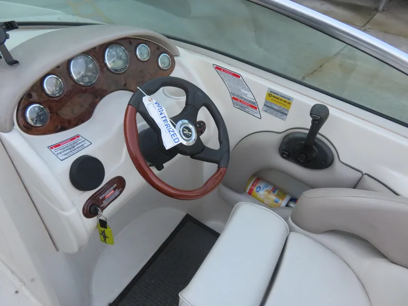 Slide: The Image of 2004 Sea Ray 220 Sundeck dashboard with wood accents and steering wheel. - 5