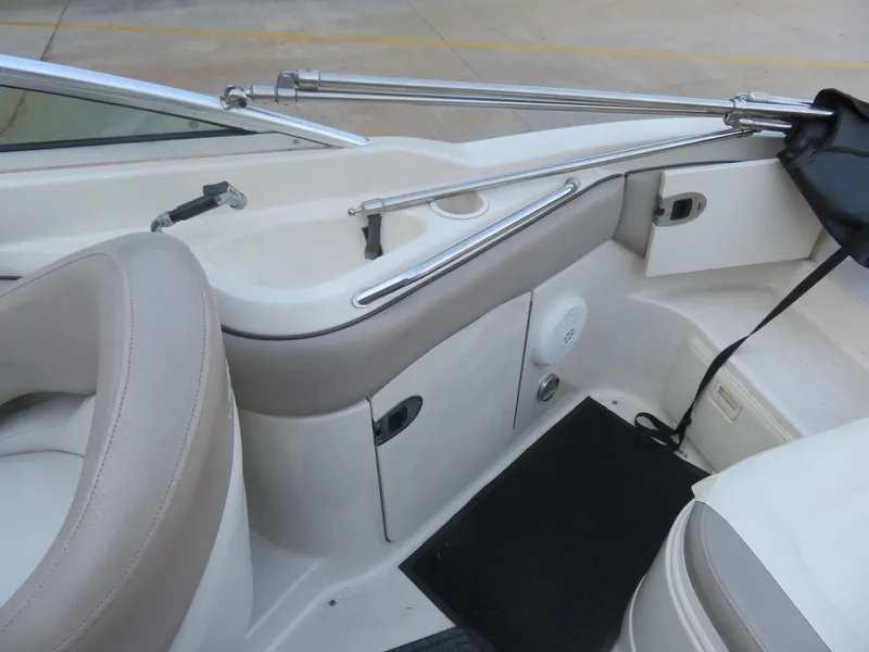 Slide: The Image of 2004 Sea Ray 220 Sundeck interior with beige seating and storage compartments. - 7