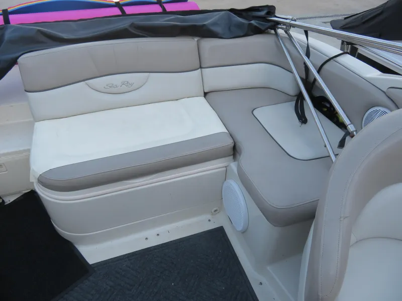 Slide: The Image of 2004 Sea Ray 220 Sundeck interior with beige seating and speaker detail. - 8