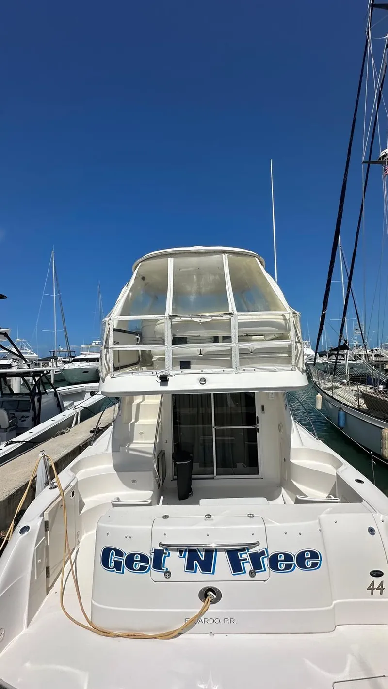 Slide: The Image of 2006 Sea Ray 44 Sedan Bridge yacht docked at marina under clear blue sky. - 2