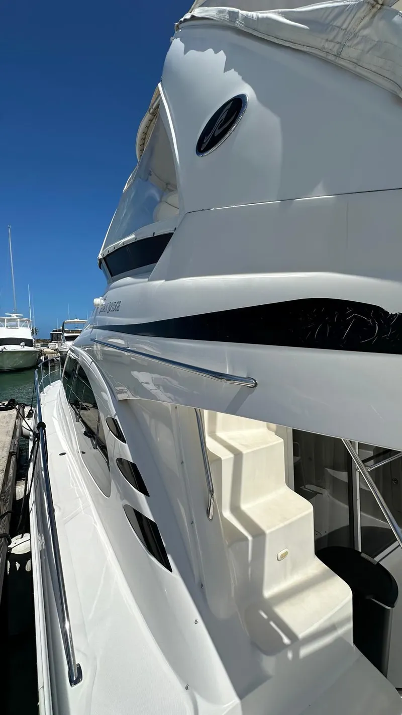 Slide: The Image of 2006 Sea Ray 44 Sedan Bridge yacht docked under clear blue sky. - 3