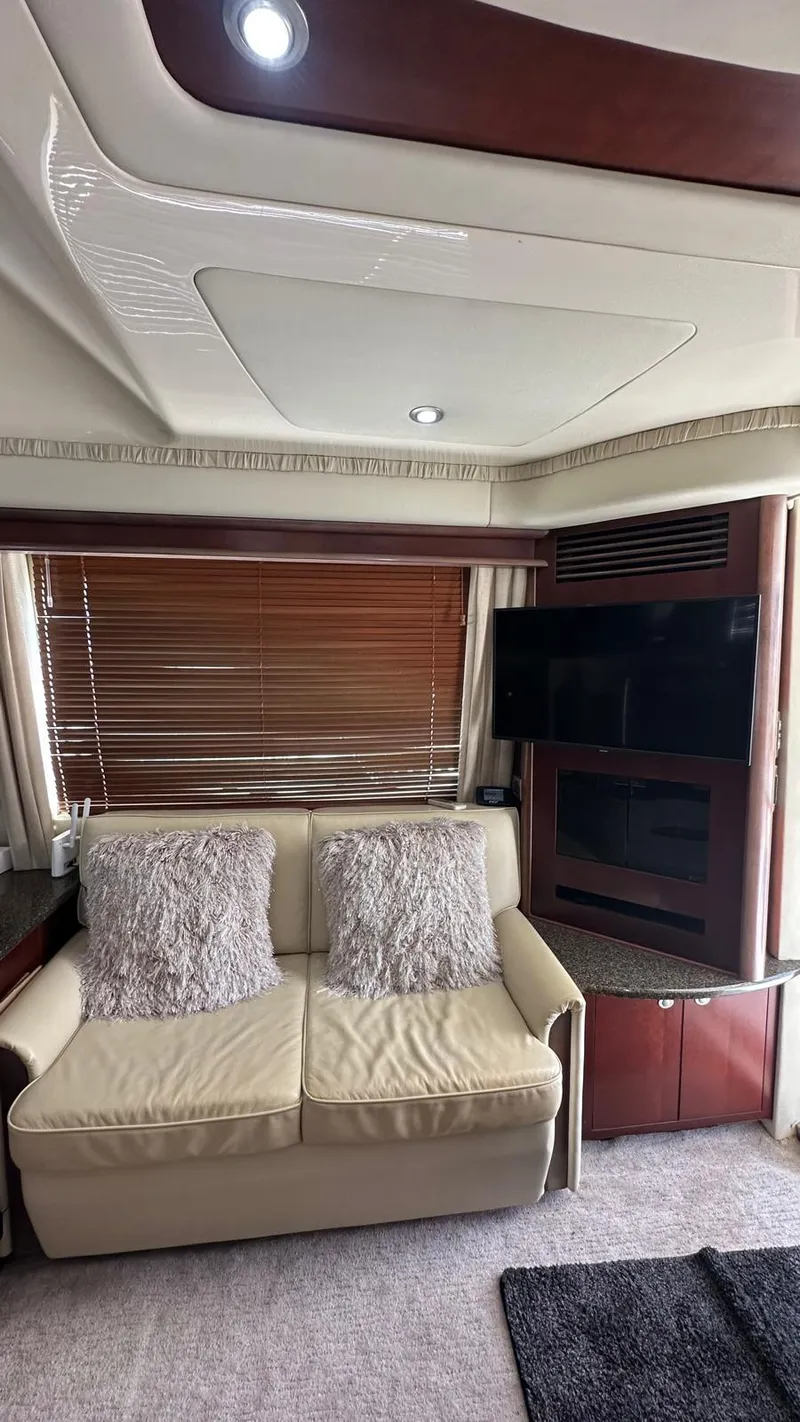 Slide: The Image of Interior of 2006 Sea Ray 44 Sedan Bridge with beige sofa and wooden blinds. - 6