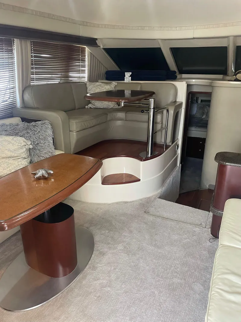 Slide: The Image of Interior of 2006 Sea Ray 44 Sedan Bridge yacht with elegant seating and wooden table. - 9