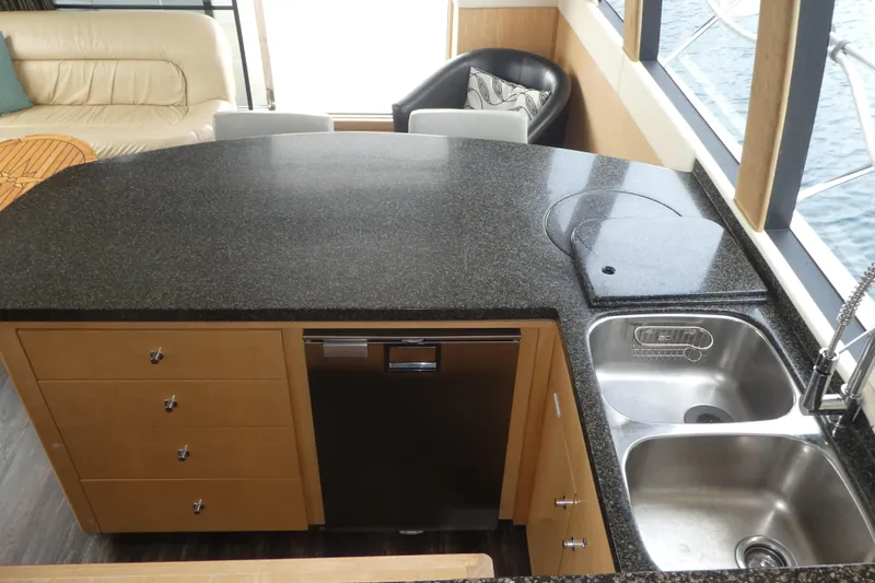 Slide: The Image of 1998 Carver 530 Voyager Pilothouse kitchen with granite countertop, sink, and modern appliances. - 10