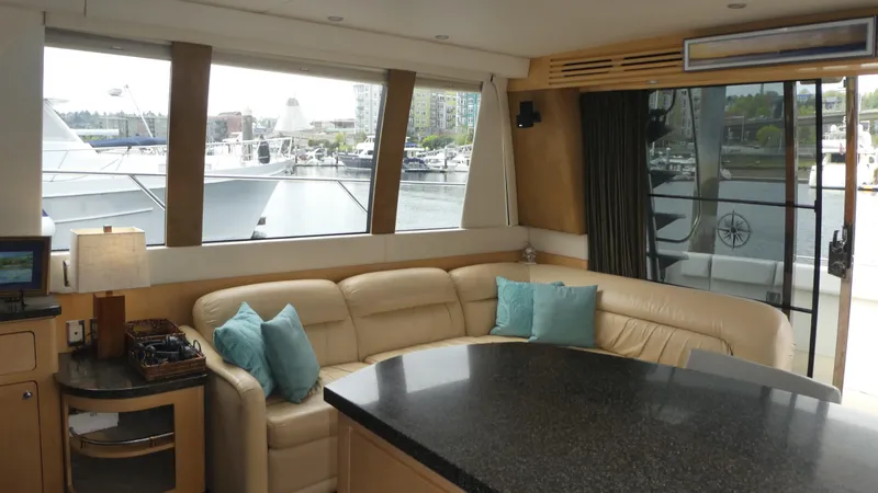Slide: The Image of Interior of 1998 Carver 530 Voyager Pilothouse with beige seating and marina view. - 12