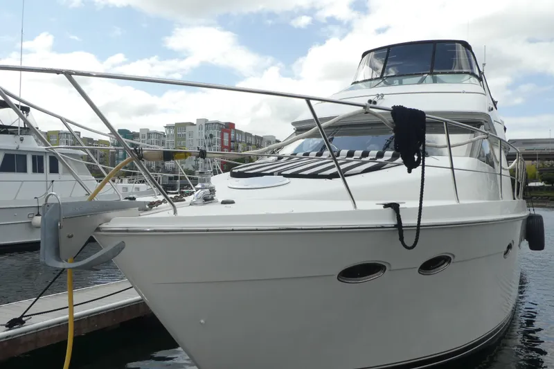 Slide: The Image of 1998 Carver 530 Voyager Pilothouse yacht docked at marina under cloudy sky. - 2