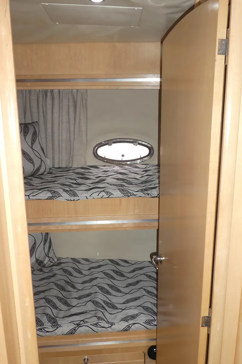 Slide: The Image of 1998 Carver 530 Voyager Pilothouse cabin with bunk beds and porthole window. - 25