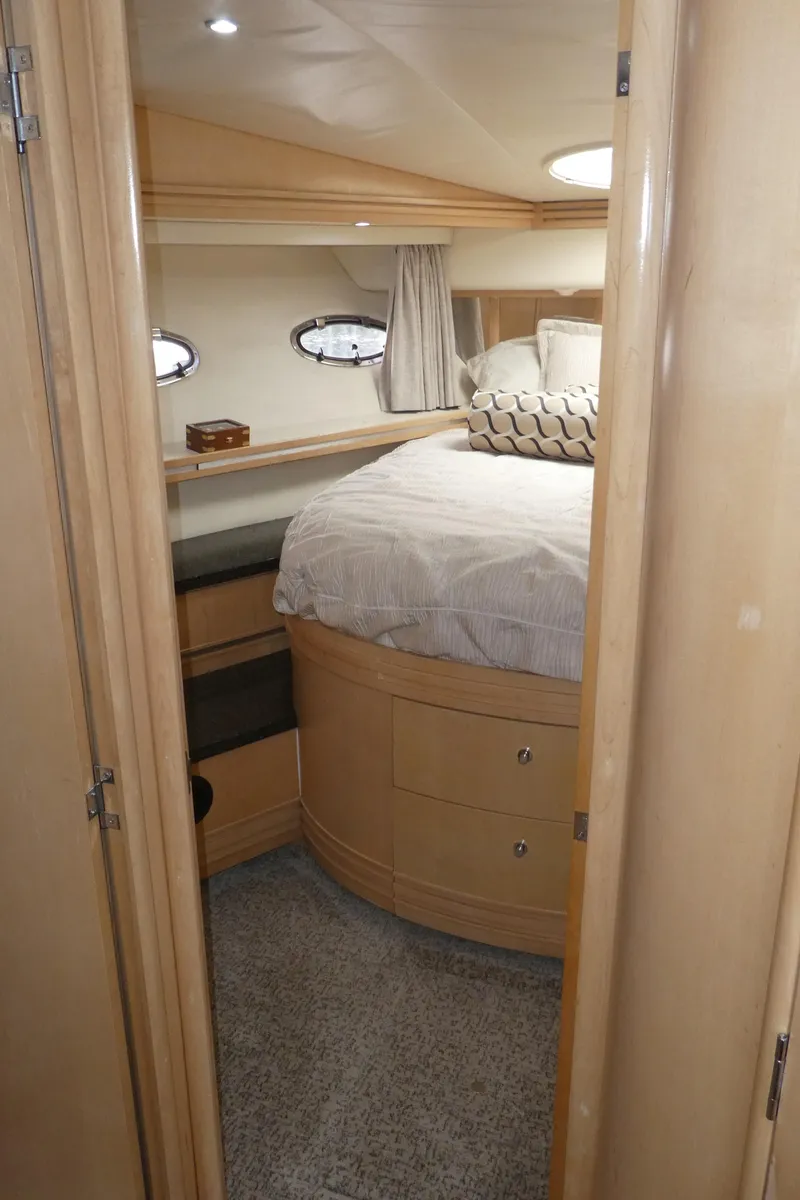 Slide: The Image of 1998 Carver 530 Voyager Pilothouse bedroom with cozy bed and wooden cabinetry. - 26