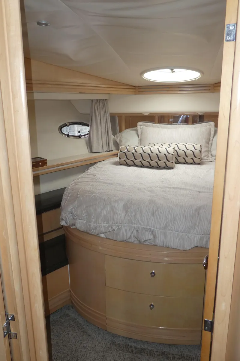 Slide: The Image of 1998 Carver 530 Voyager Pilothouse bedroom with round bed and porthole window. - 27