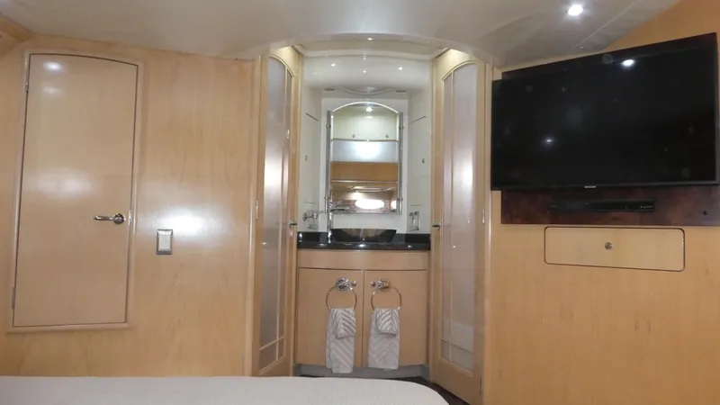 Slide: The Image of 1998 Carver 530 Voyager Pilothouse interior with wood paneling, TV, and bathroom view. - 38