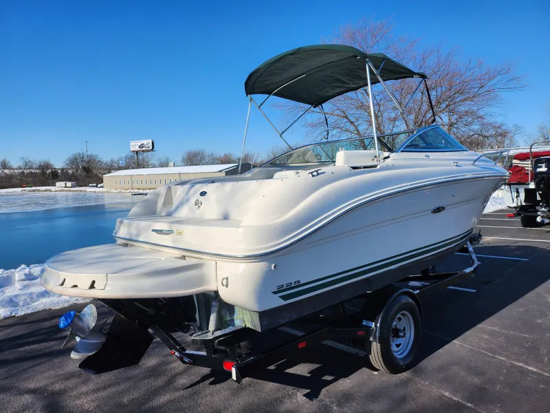 Slide: The Image of 2004 Sea Ray 225 Weekender boat on trailer, parked near a snowy lake. - 1