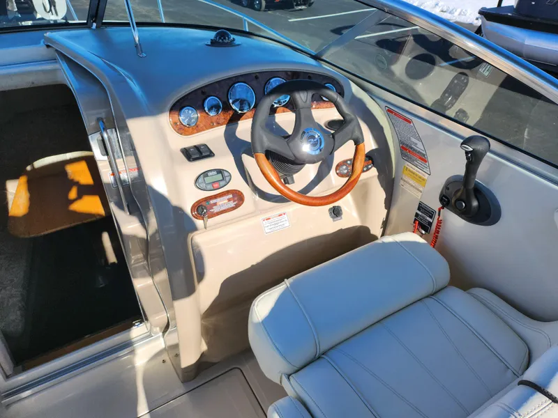Slide: The Image of 2004 Sea Ray 225 Weekender boat cockpit with steering wheel and control panel. - 11