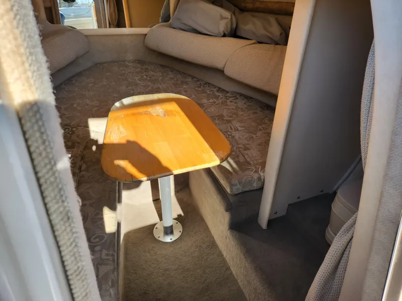 Slide: The Image of Interior cabin of 2004 Sea Ray 225 Weekender with cozy seating and wooden table. - 14