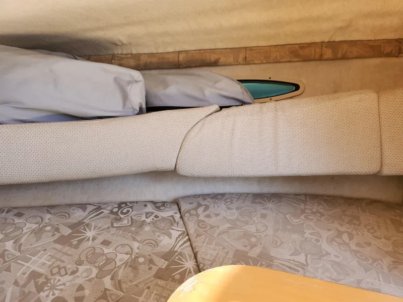 Slide: The Image of Interior cabin of 2004 Sea Ray 225 Weekender with cushioned seating and small window. - 15