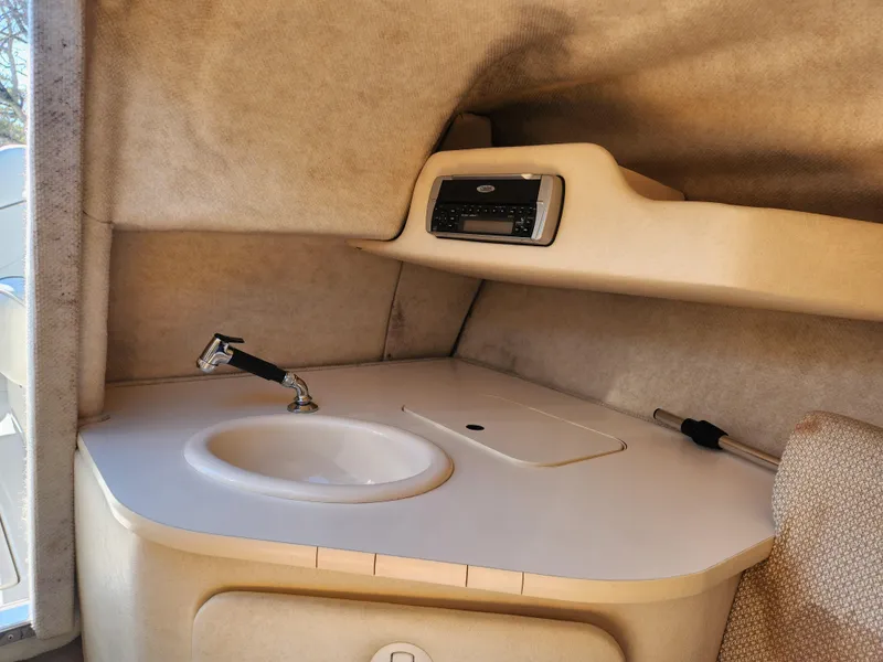 Slide: The Image of 2004 Sea Ray 225 Weekender cabin interior with sink and stereo system. - 17