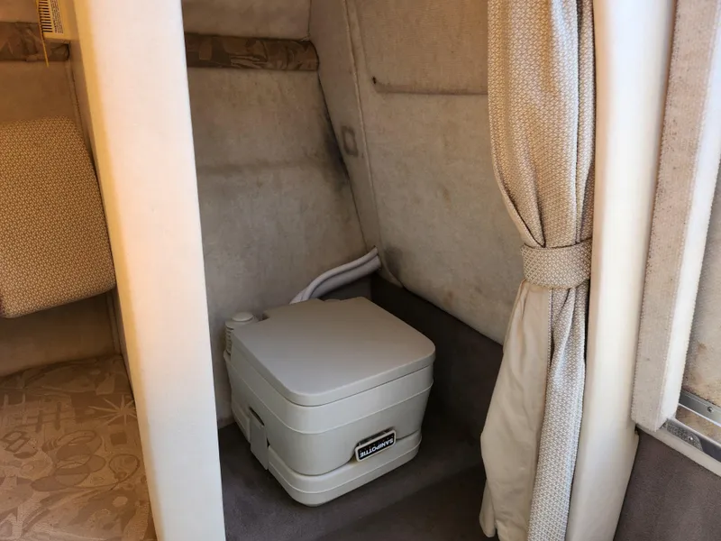 Slide: The Image of 2004 Sea Ray 225 Weekender cabin with portable toilet and privacy curtain. - 18