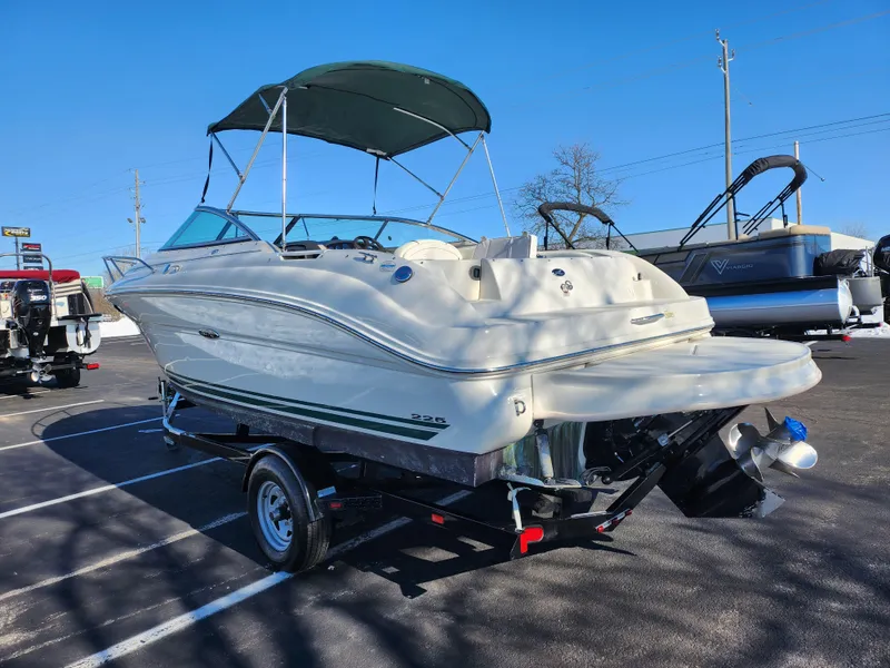 Slide: The Image of 2004 Sea Ray 225 Weekender boat on trailer with canopy, parked in a lot. - 3