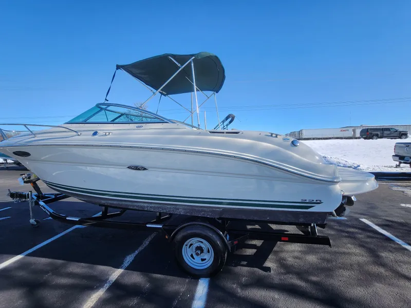 Slide: The Image of 2004 Sea Ray 225 Weekender boat on trailer with canopy, parked outdoors. - 4