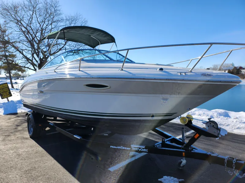 Slide: The Image of 2004 Sea Ray 225 Weekender boat on trailer, parked outdoors on a sunny day. - 8