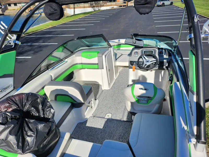 Slide: The Image of 2016 Chaparral Vortex 203 VRX boat interior with green accents, parked in a lot. - 10
