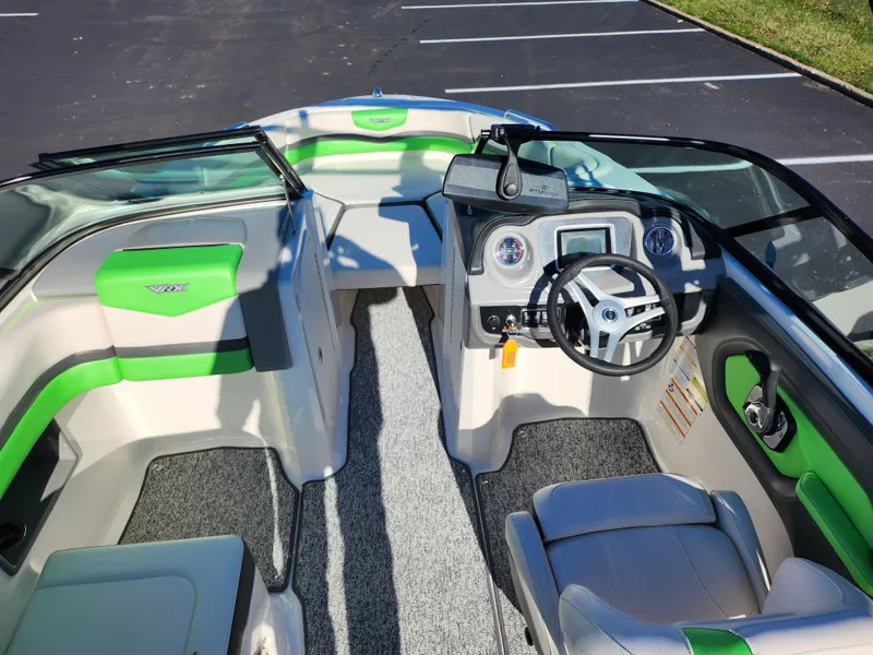 Slide: The Image of 2016 Chaparral Vortex 203 VRX boat interior with green accents and modern dashboard. - 11