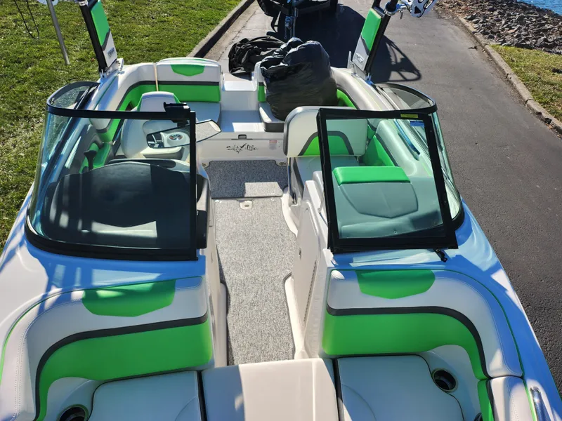 Slide: The Image of 2016 Chaparral Vortex 203 VRX boat with green and white interior, parked on a road. - 19