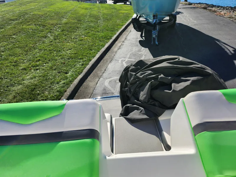 Slide: The Image of 2016 Chaparral Vortex 203 VRX boat interior with green accents, parked on a sunny day. - 23