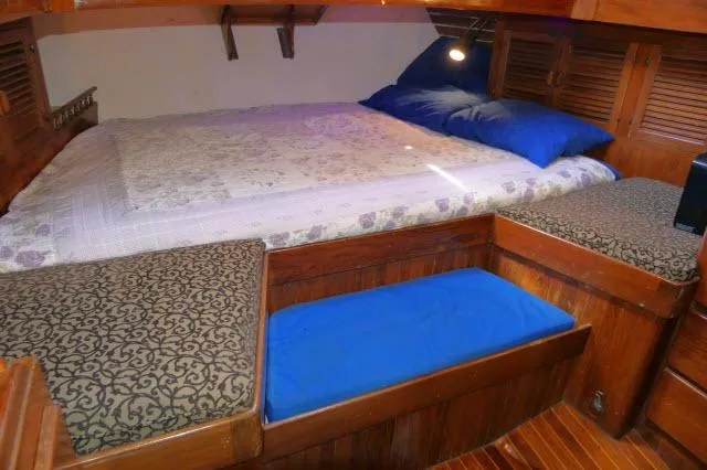Slide: The Image of Cozy cabin interior of 1978 Brewer 45 Ketch with bed and wooden furnishings. - 16