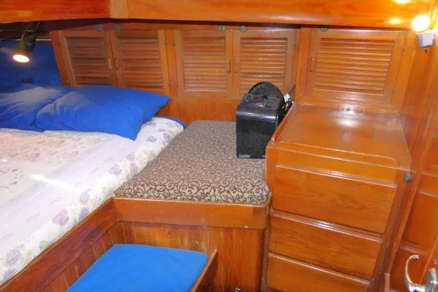 Slide: The Image of Cozy cabin interior of 1978 Brewer 45 Ketch with wooden furnishings and bedding. - 18