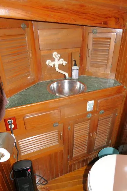 Slide: The Image of Wooden bathroom interior of 1978 Brewer 45 Ketch with sink and storage cabinets. - 19