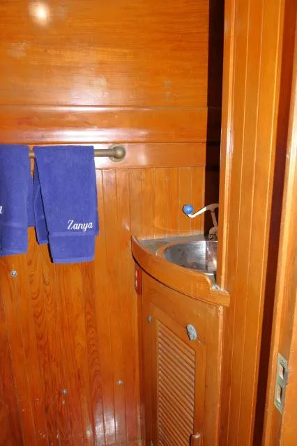 Slide: The Image of 1978 Brewer 45 Ketch bathroom with wooden paneling and compact sink. - 21