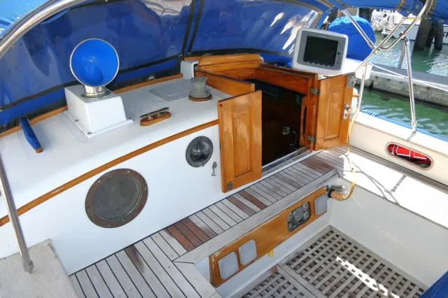 Slide: The Image of 1978 Brewer 45 Ketch cockpit with wooden accents, blue canopy, and nautical equipment. - 22