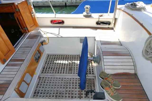 Slide: The Image of 1978 Brewer 45 Ketch cockpit with wooden flooring and nautical equipment. - 26